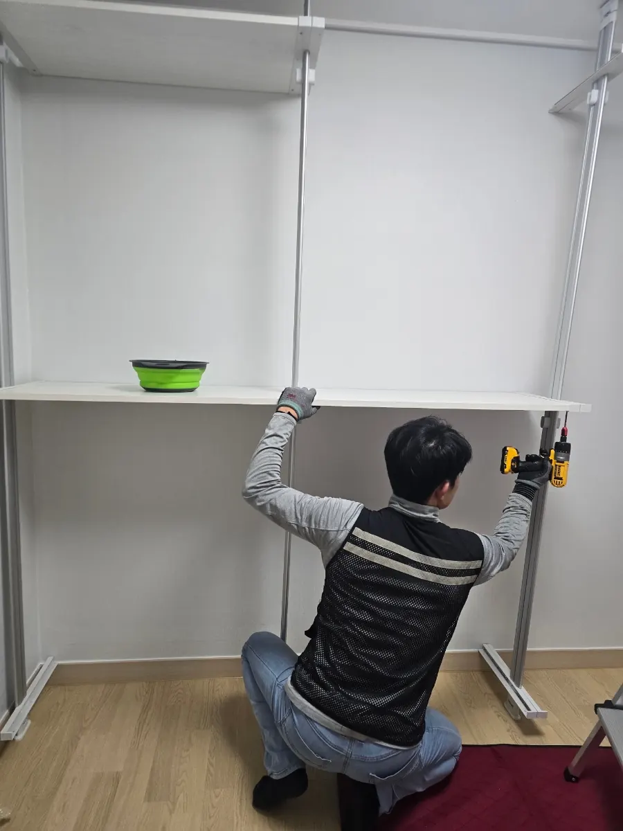 수평계로 확인하며 선반과 옷봉을 체결합니다.